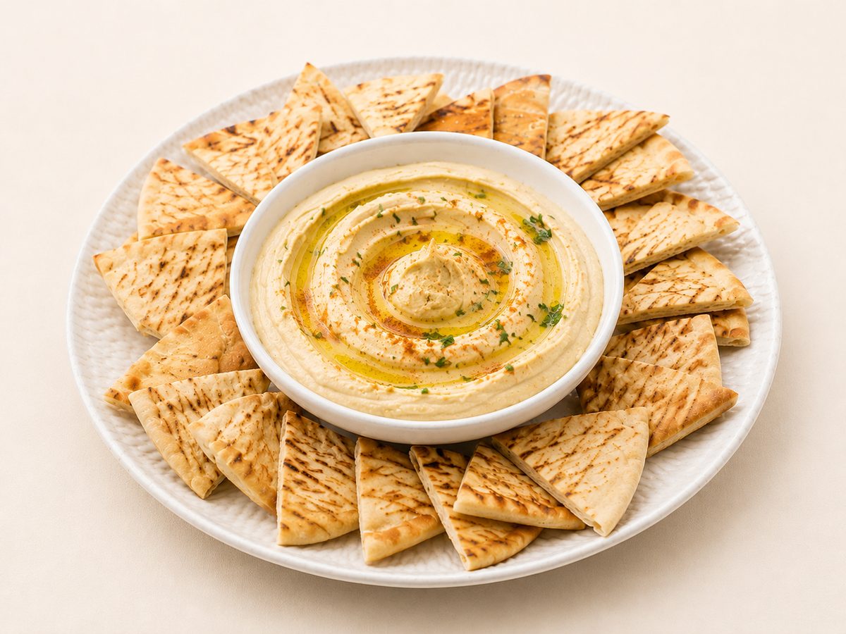 Hummus and pita platter with olives and vegetables