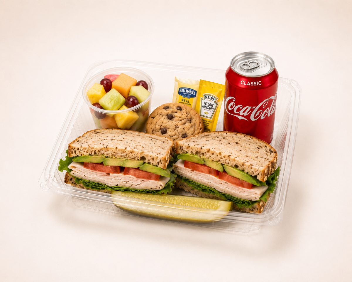 Sandwich box lunch with a turkey sandwich, fruit cup, cookie and drink